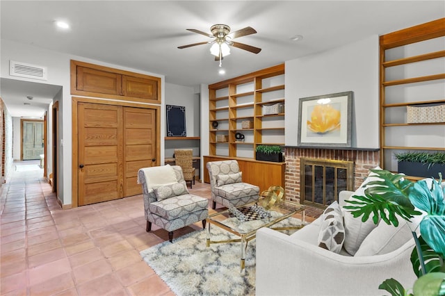 living room featuring ceiling fan, a fireplace, light tile patterned floors, and built in features