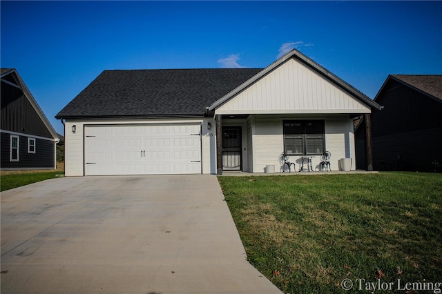 view of front of house featuring a front yard, a garage, and covered porch