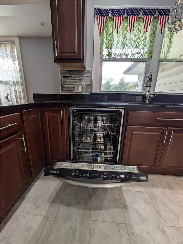 bar with black dishwasher, sink, and tasteful backsplash