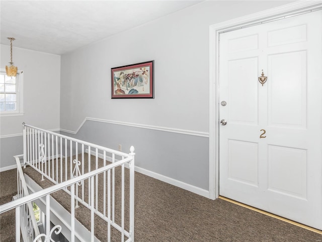 hall featuring dark colored carpet