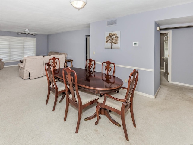 dining room with light colored carpet and ceiling fan