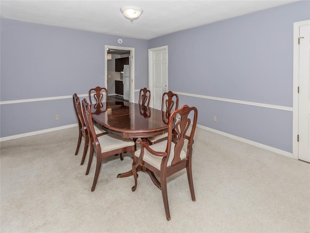 dining space featuring light carpet