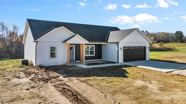 modern farmhouse style home featuring central AC unit and a garage