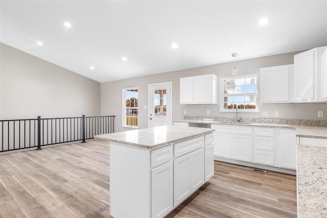 kitchen with a wealth of natural light, white cabinetry, and light hardwood / wood-style flooring