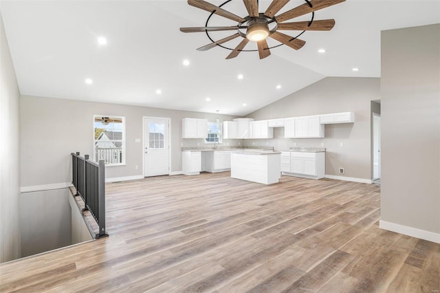 kitchen with light hardwood / wood-style flooring, white cabinets, ceiling fan, and a kitchen island