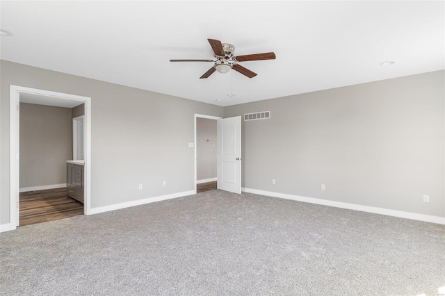 unfurnished bedroom with ensuite bath, carpet flooring, and ceiling fan