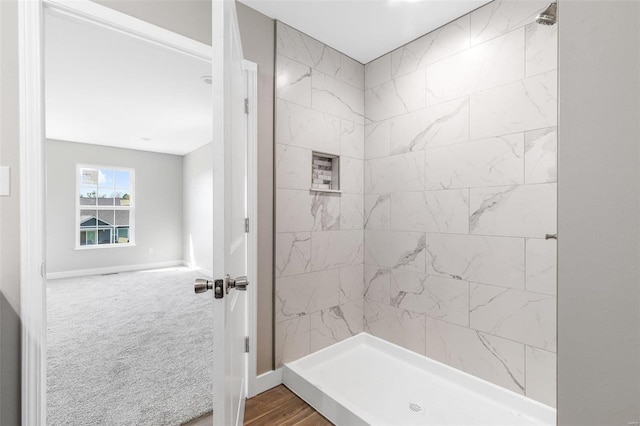 bathroom featuring a tile shower and hardwood / wood-style floors