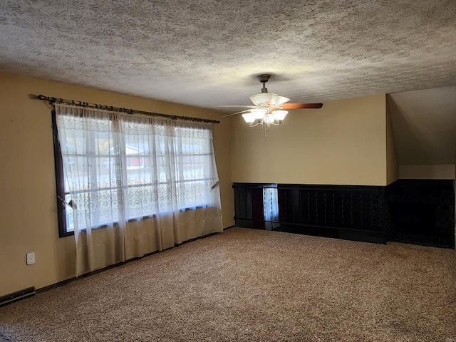 carpeted spare room with ceiling fan, a textured ceiling, and a wealth of natural light