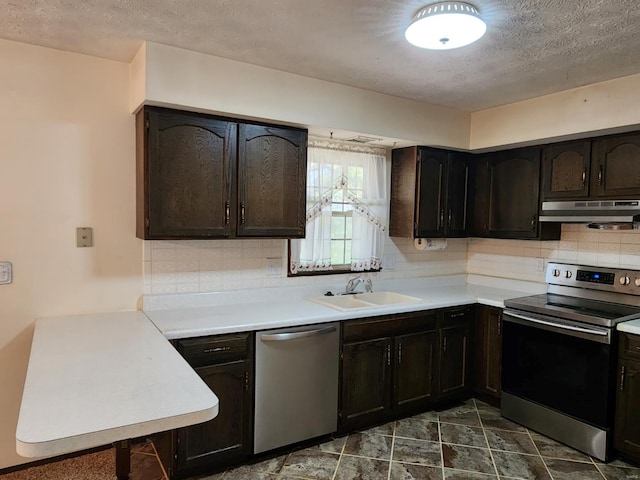 kitchen featuring decorative backsplash, stainless steel appliances, sink, dark brown cabinetry, and a textured ceiling