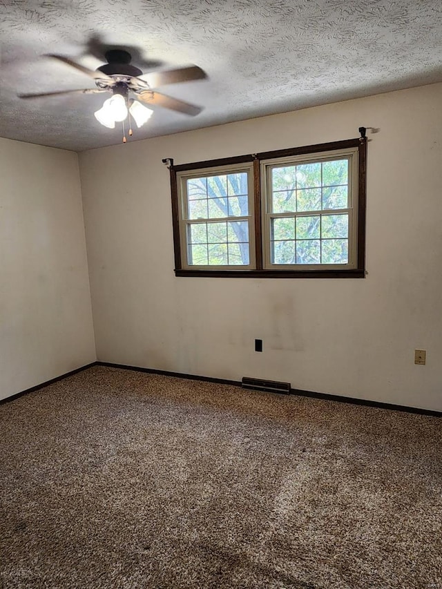 empty room with carpet, ceiling fan, and a textured ceiling