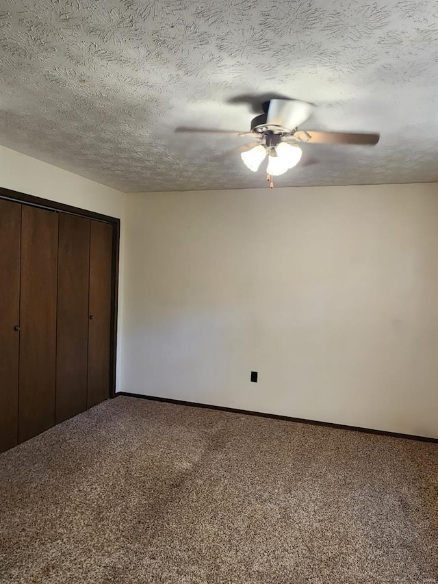 unfurnished bedroom with a closet, ceiling fan, carpet, and a textured ceiling