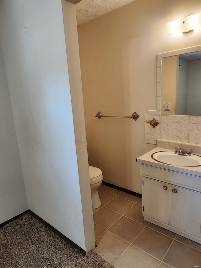 bathroom featuring vanity, toilet, and tile patterned flooring