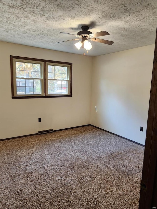 spare room with a textured ceiling, carpet floors, and ceiling fan