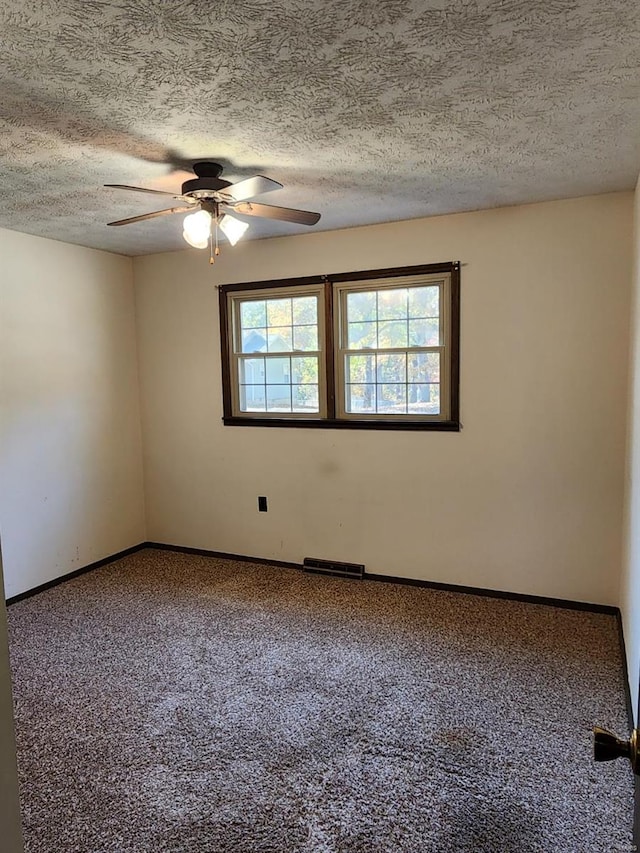 carpeted empty room featuring a textured ceiling and ceiling fan