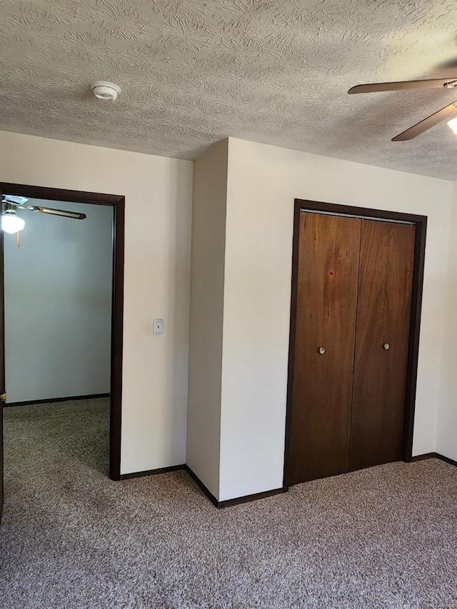 unfurnished bedroom with a closet, carpet floors, a textured ceiling, and ceiling fan