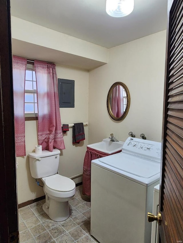 bathroom with washer / dryer, electric panel, toilet, and sink