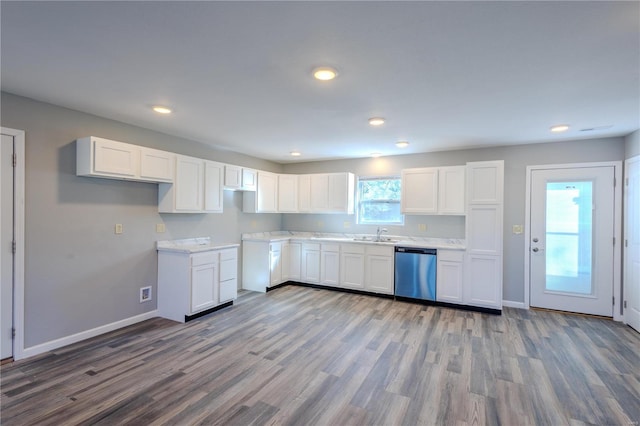 kitchen featuring hardwood / wood-style flooring, stainless steel dishwasher, white cabinets, and sink