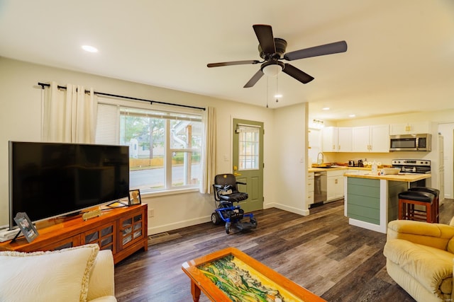 living room featuring sink, ceiling fan, and dark hardwood / wood-style flooring