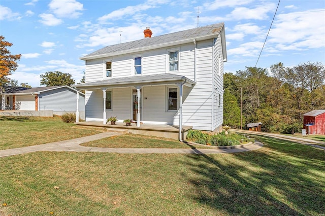 view of front of property featuring covered porch, a storage unit, and a front lawn