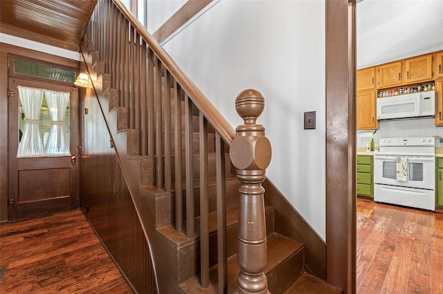 stairs with hardwood / wood-style flooring and ornamental molding