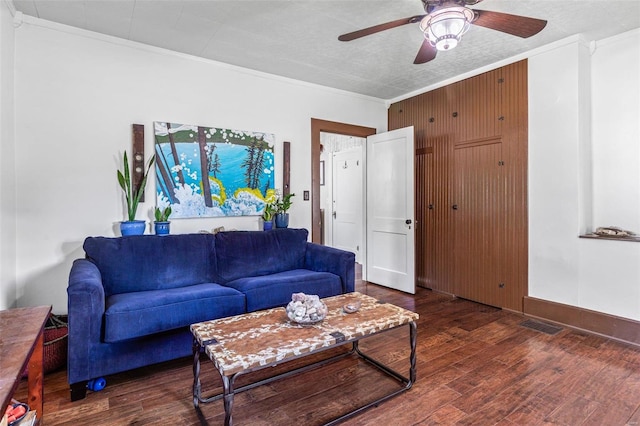 living room with crown molding, ceiling fan, and dark hardwood / wood-style flooring