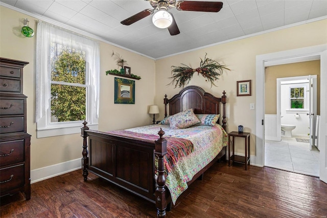 bedroom with connected bathroom, ceiling fan, multiple windows, and dark hardwood / wood-style flooring