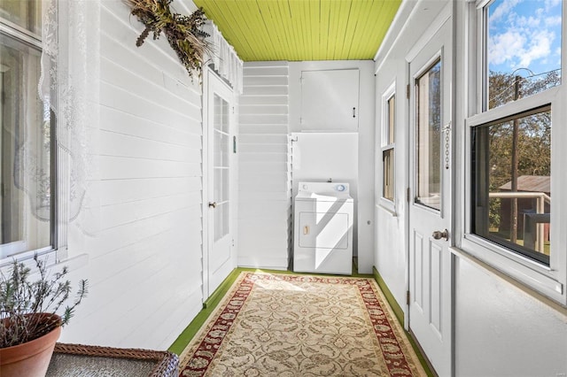 interior space featuring wood walls, wooden ceiling, and washer / clothes dryer