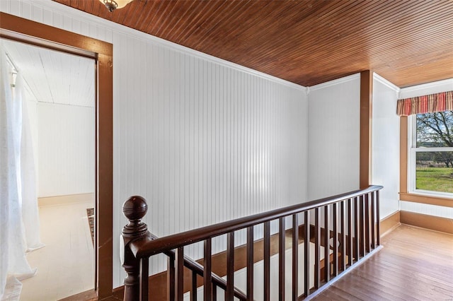 corridor with crown molding, wood walls, hardwood / wood-style flooring, and wooden ceiling