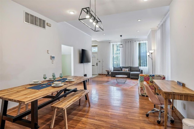 dining room featuring a notable chandelier, ornamental molding, and wood-type flooring