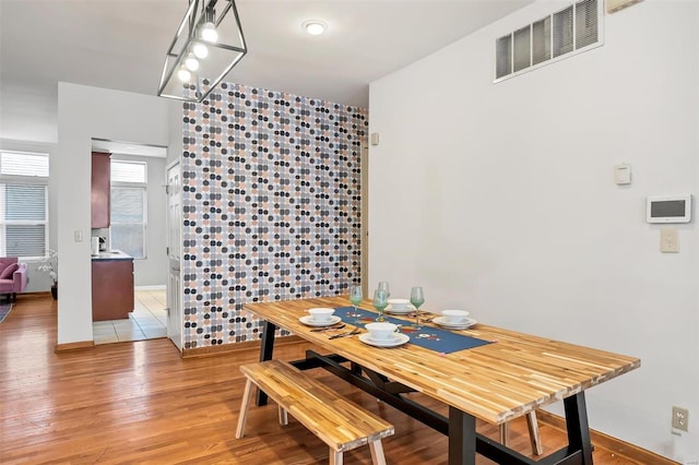 dining space featuring tile walls and light wood-type flooring