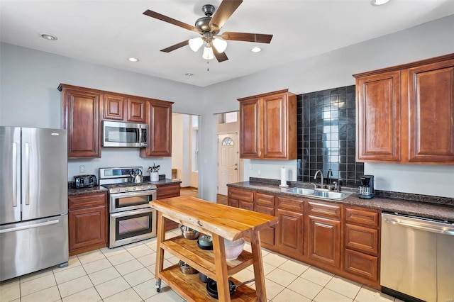 kitchen with sink, ceiling fan, stainless steel appliances, and light tile patterned floors