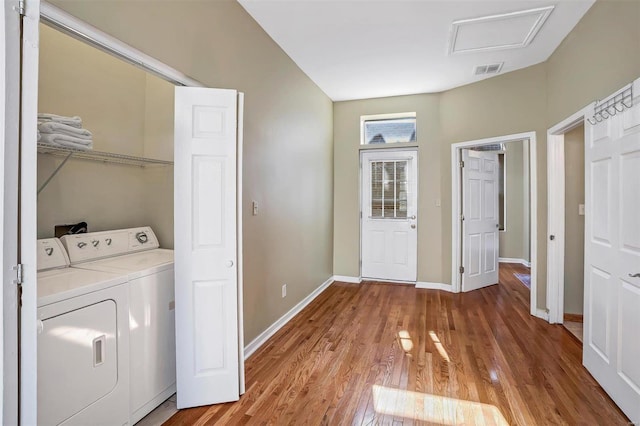 clothes washing area featuring hardwood / wood-style flooring and separate washer and dryer