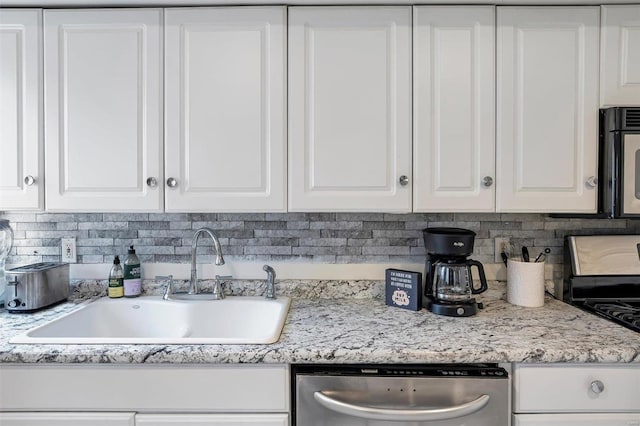 kitchen featuring light stone counters, backsplash, white cabinetry, black appliances, and sink