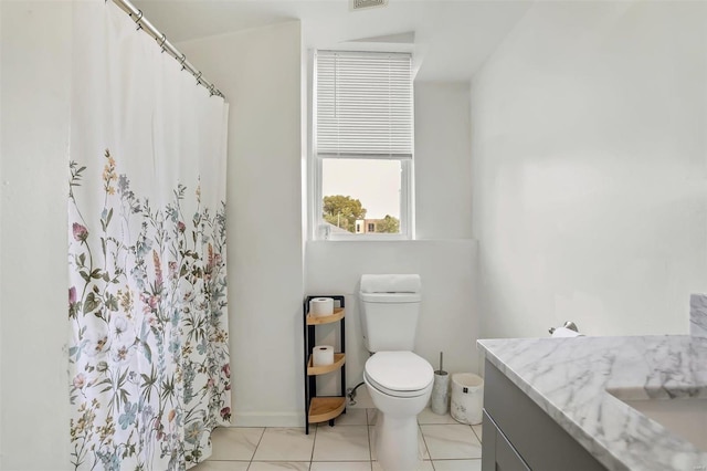 bathroom with toilet, curtained shower, vanity, and tile patterned flooring