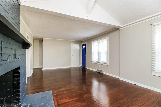 unfurnished living room featuring lofted ceiling, a textured ceiling, dark hardwood / wood-style flooring, and a brick fireplace