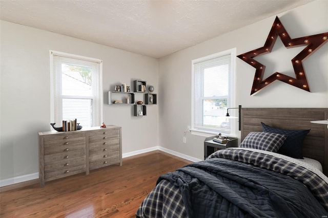 bedroom featuring a textured ceiling and dark hardwood / wood-style flooring