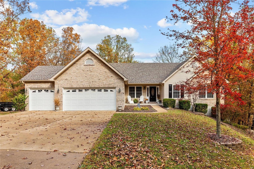 view of front of house featuring a garage, a shingled roof, concrete driveway, and brick siding