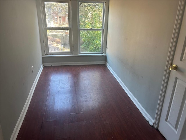 unfurnished room with dark hardwood / wood-style flooring