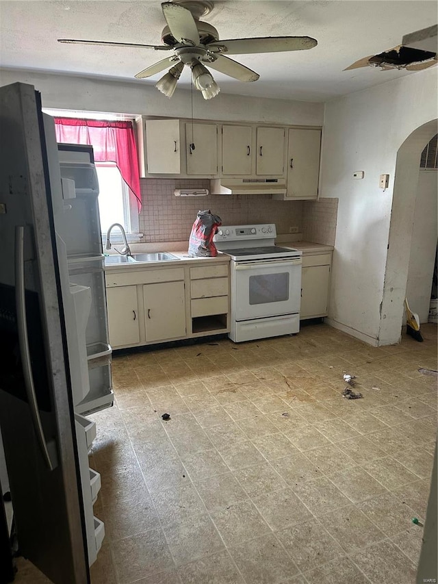 kitchen with white appliances, sink, cream cabinetry, ceiling fan, and decorative backsplash