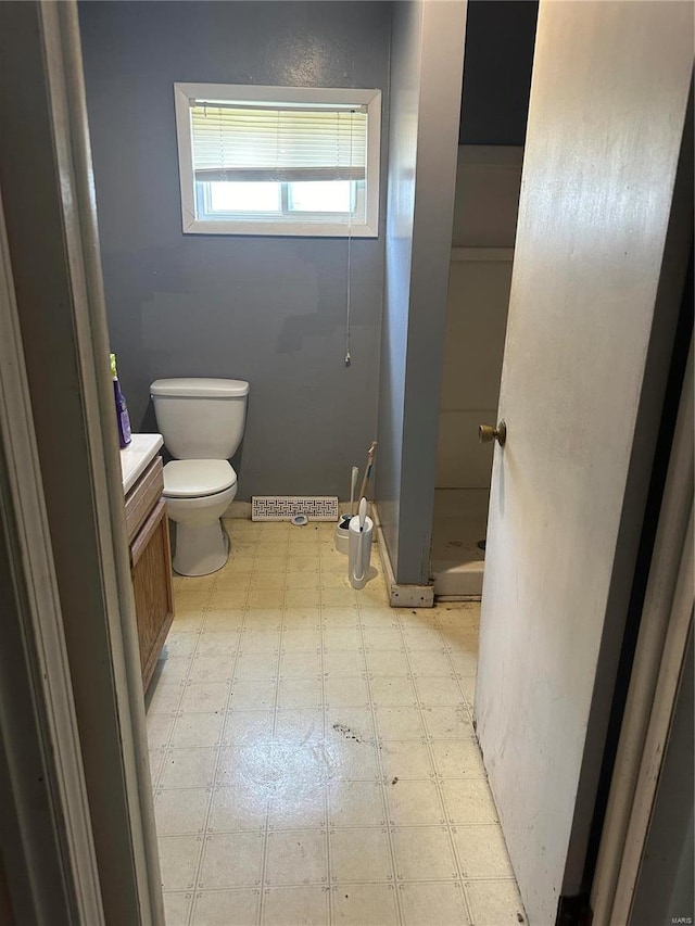 bathroom with toilet, walk in shower, and vanity