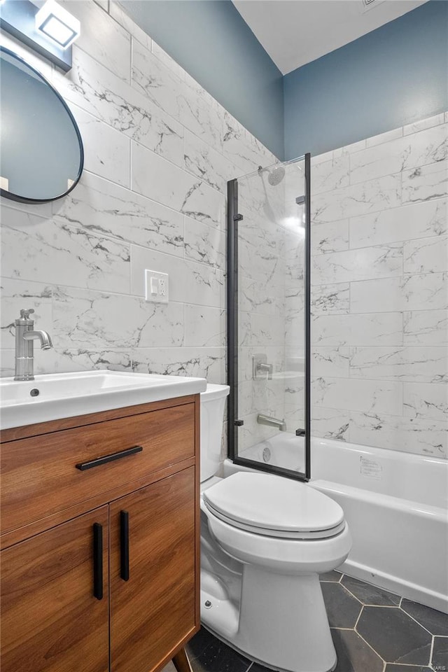 full bathroom with tiled shower / bath, vanity, toilet, and tile patterned floors