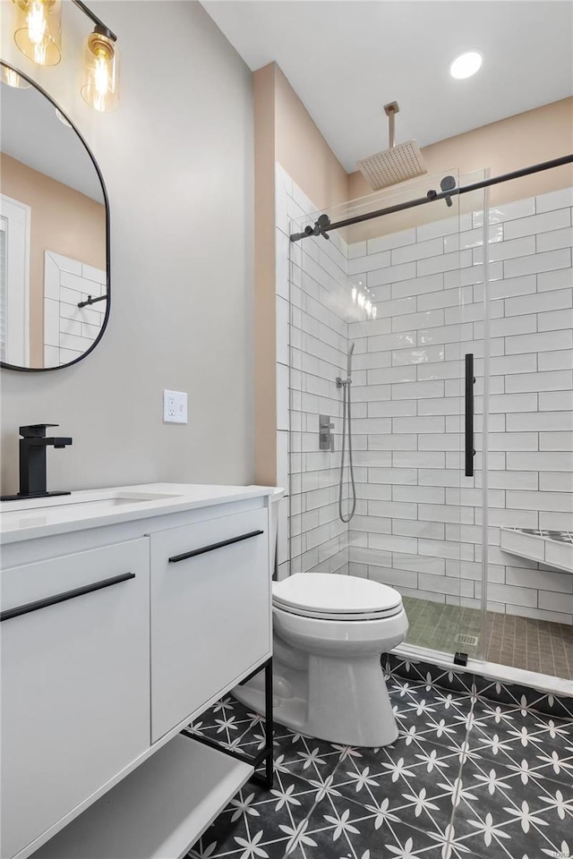 bathroom featuring vanity, toilet, and a shower with door