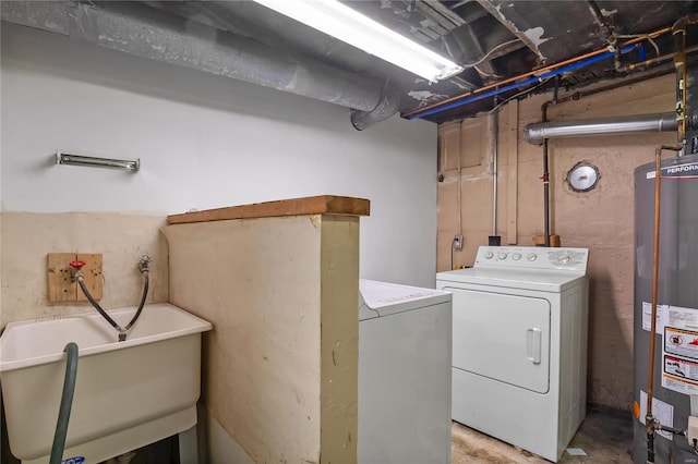 washroom with washing machine and dryer, sink, and gas water heater