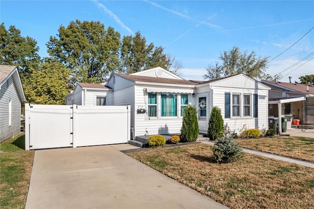 view of front of property with a gate, a front lawn, and concrete driveway