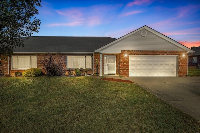 ranch-style house with a garage and a lawn