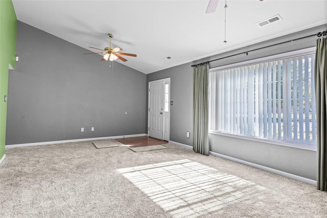 spare room featuring lofted ceiling, light colored carpet, and ceiling fan