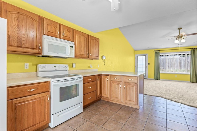 kitchen featuring white appliances, lofted ceiling, light tile patterned floors, and kitchen peninsula