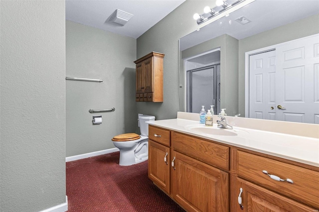 bathroom featuring vanity, toilet, and a shower with shower door