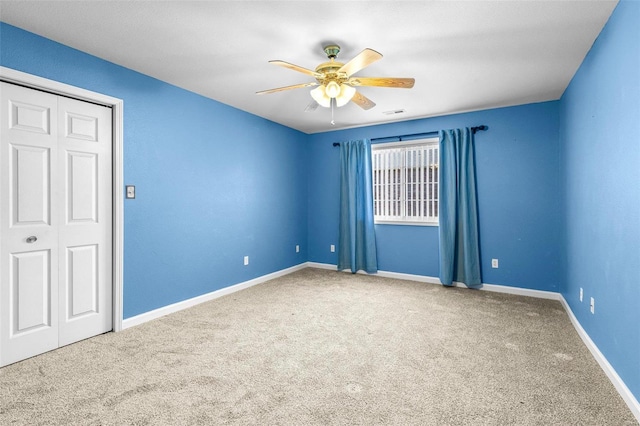 spare room featuring ceiling fan and carpet flooring