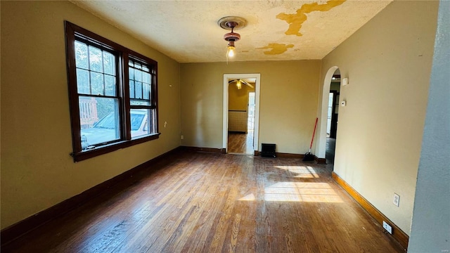 empty room with a textured ceiling and hardwood / wood-style flooring